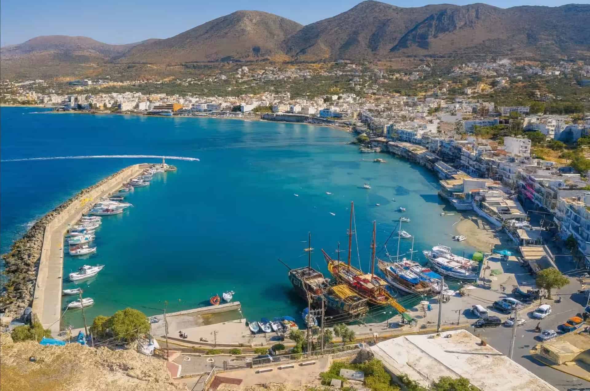 Πανοραμική εναέρια θέα του παλιού λιμανιού Χερσονήσου με παραλιακή περατζάδα, κρυστάλλινα τιρκουάζ νερά και σκάφη, Κρήτη