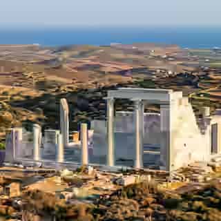 Colonnes et murs en marbre restaurés du temple antique de Déméter à Gyroulas, Naxos, avec le paysage cycladique derrière