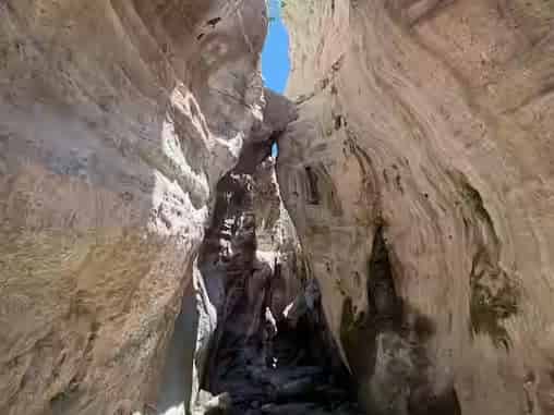 Schmale Felswände der Avakas-Schlucht bei Paphos, Zypern, mit steinigem Pfad und blauem Himmel darüber.