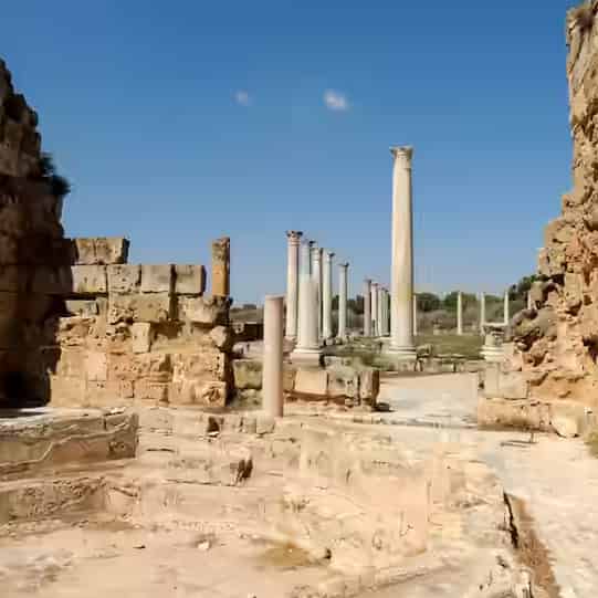 Steinruinen und stehende Säulen in der antiken Stätte Kourion bei Limassol, Zypern, unter blauem Himmel.