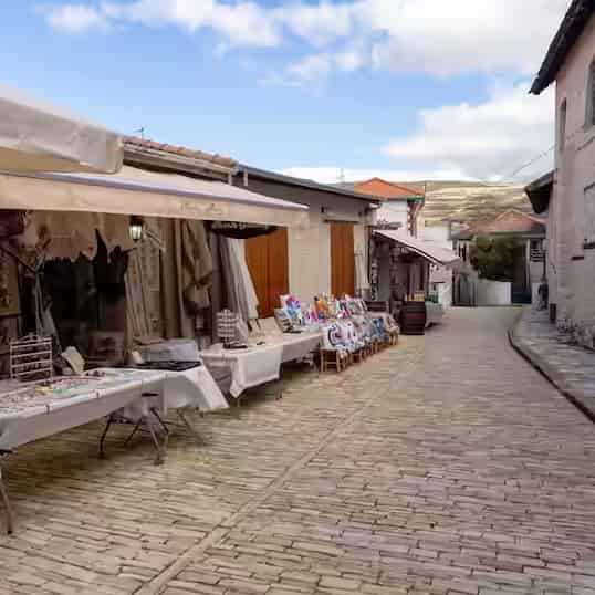 Kopfsteingepflasterte Gasse mit Läden und Marktständen für lokales Kunsthandwerk im Dorf Omodos, Zypern.
