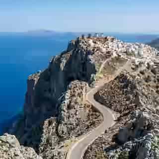 Route de montagne sinueuse à Karpathos vers Olympos avec vue spectaculaire sur la mer Égée et sommets calcaires escarpés, nord du Dodécanèse, Grèce