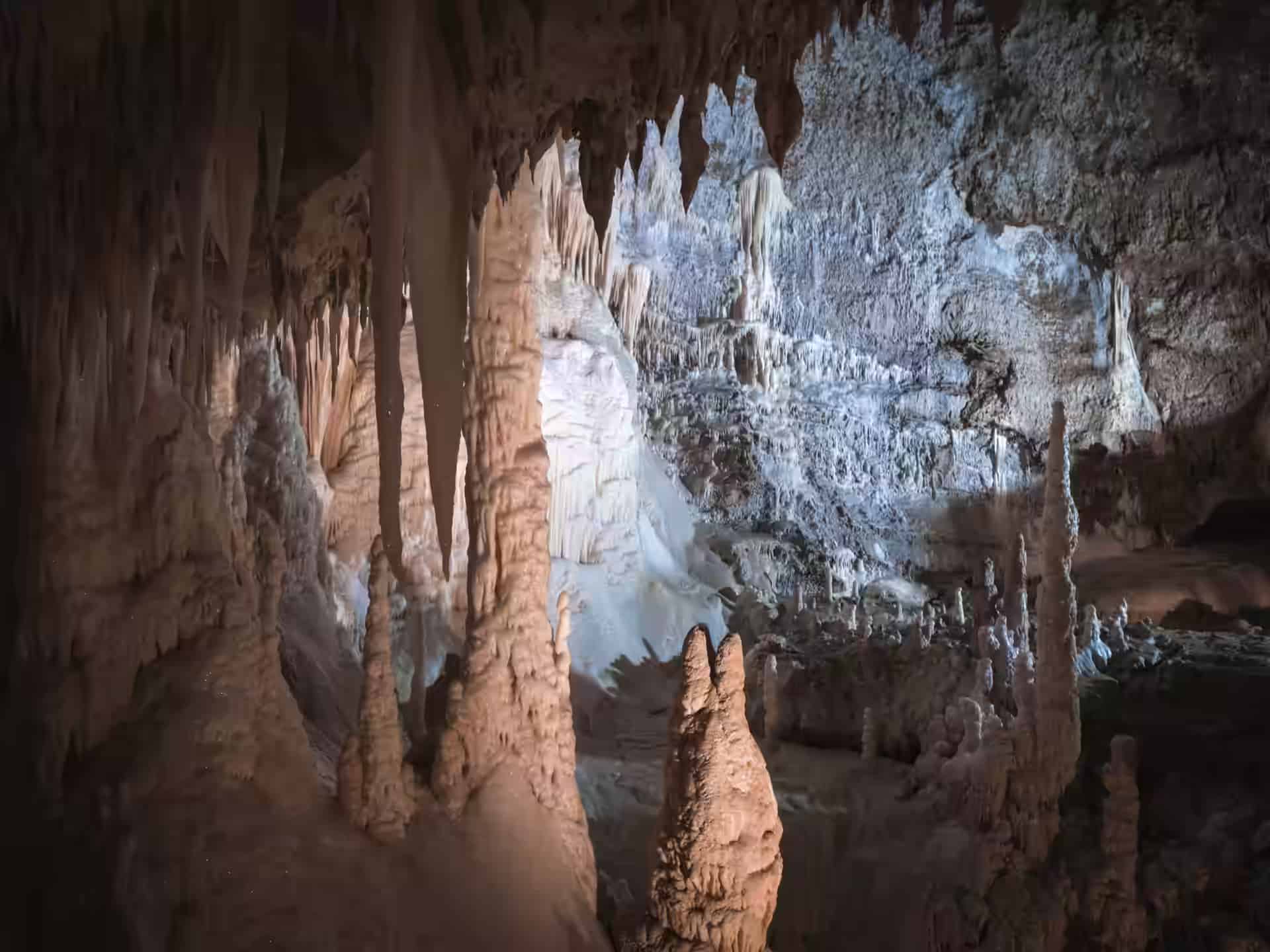Beleuchtete Stalaktiten und Stalagmiten in einer Kammer der Marmorhöhle von Gadime.