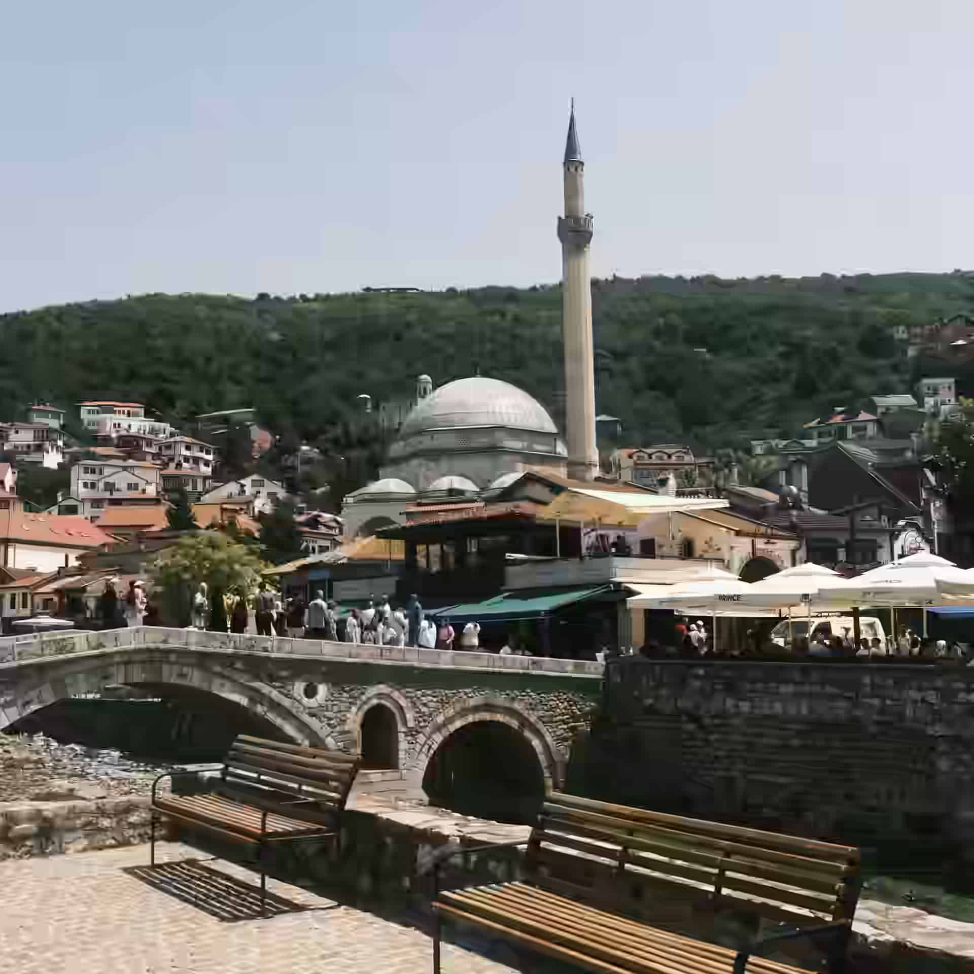 El puente de piedra en arco de Prizren sobre el río Lumbardhi, con la mezquita de Sinan Pasha y el casco antiguo detrás.