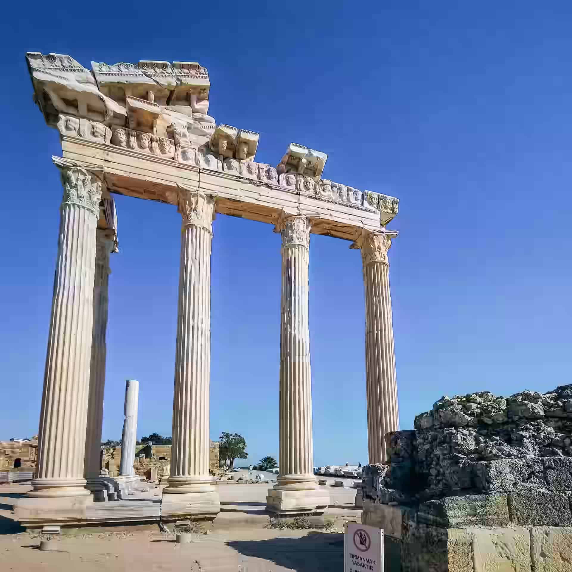 Coloanele înalte de marmură ale templului lui Apollo în ruine pe un cer albastru senin, la Side, lângă Antalya, Turcia.