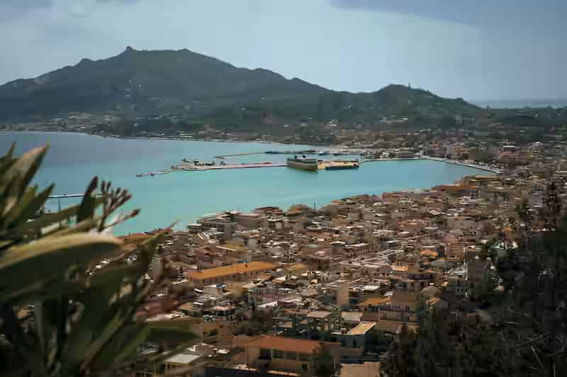 Nadmorski bulwar miasta Zakynthos z pastelowymi neoklasycznymi budynkami, promenadą portową i zacumowanymi łodziami, Zante, Wyspy Jońskie, Grecja