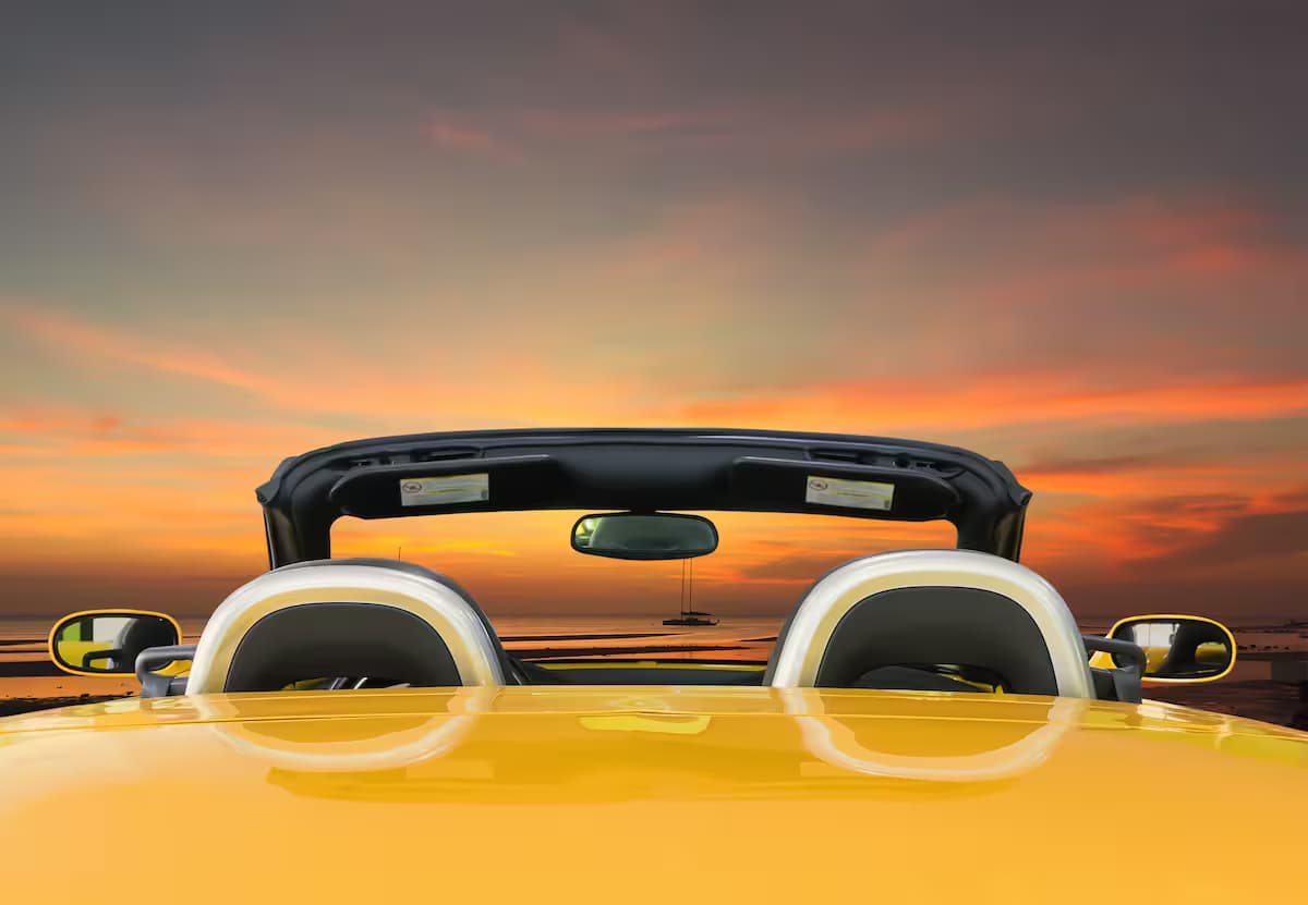 Luxury vintage car on road against sunset sky