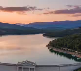 Panoramiczny widok na zbiornik jeziora Maraton i marmurową tamę o zachodzie słońca.
