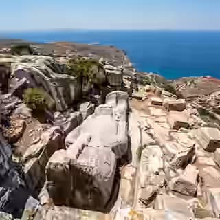 The colossal unfinished Apollonas Kouros carved into the rock face of a clifftop marble quarry above the Aegean Sea, north Naxos, Greece