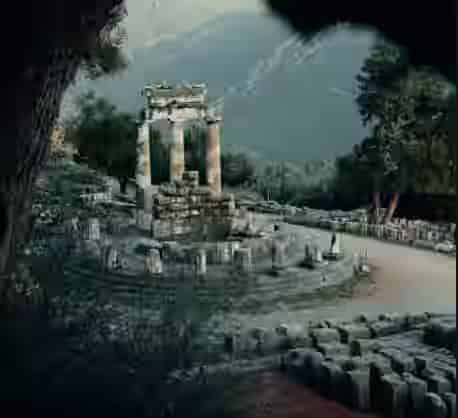 The circular ancient Tholos of Athena Pronaia at Delphi archaeological site, surrounded by green mountains, an iconic Greek landmark for road trips from Athens.