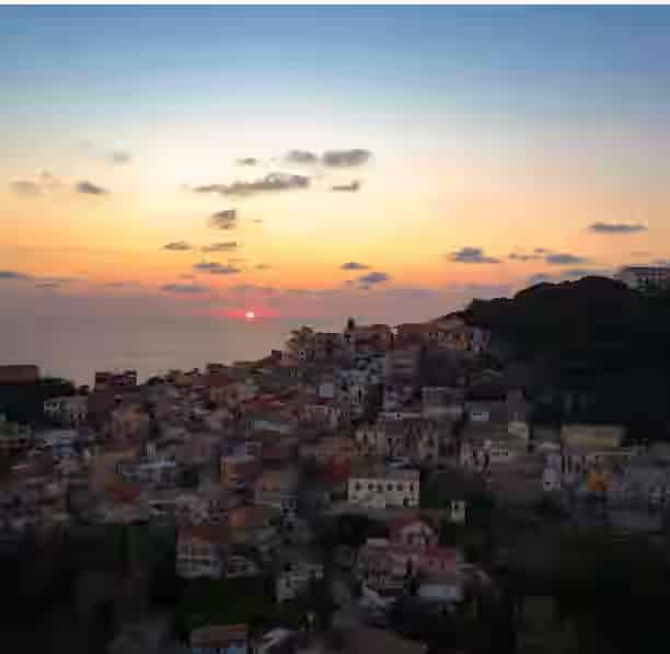 Panoramic view of historic Corfu Old Town with orange-tiled rooftops and the Venetian Old Fortress, a key destination for travelers renting a car.