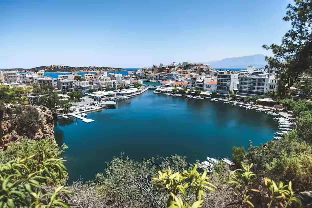 Υπερυψωμένη θέα στη στρογγυλή λίμνη Βουλισμένη, το λιμάνι και την παραλιακή περατζάδα στο κέντρο του Αγίου Νικολάου, Ανατολική Κρήτη