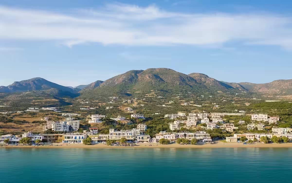 Aerial view of Analipsi coastal town and resort area with traditional buildings and mountainous landscape, Heraklion, Crete