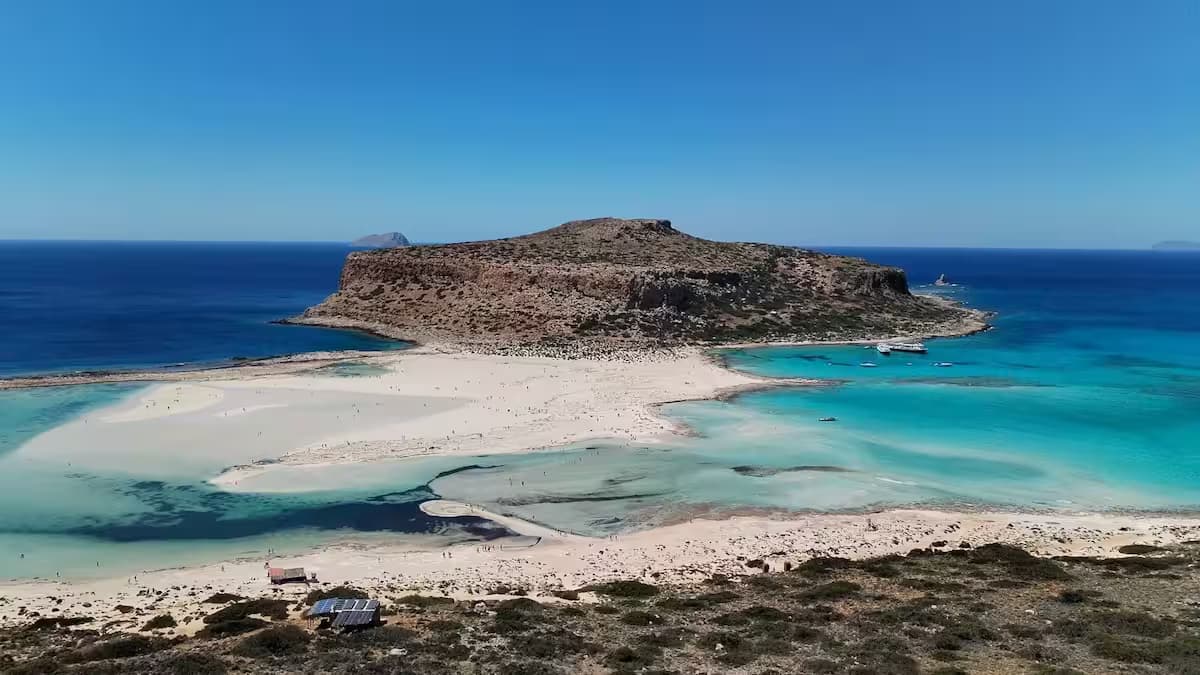 Elevated view of Balos Lagoon and Imeri Gramvousa island, Chania, Northwest Crete, featuring turquoise and deep blue water and a pristine sandy beach