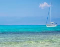 Sailboat anchored in the crystal-clear turquoise waters off Chrissi Island (Gaidouronisi), South Crete, Greece