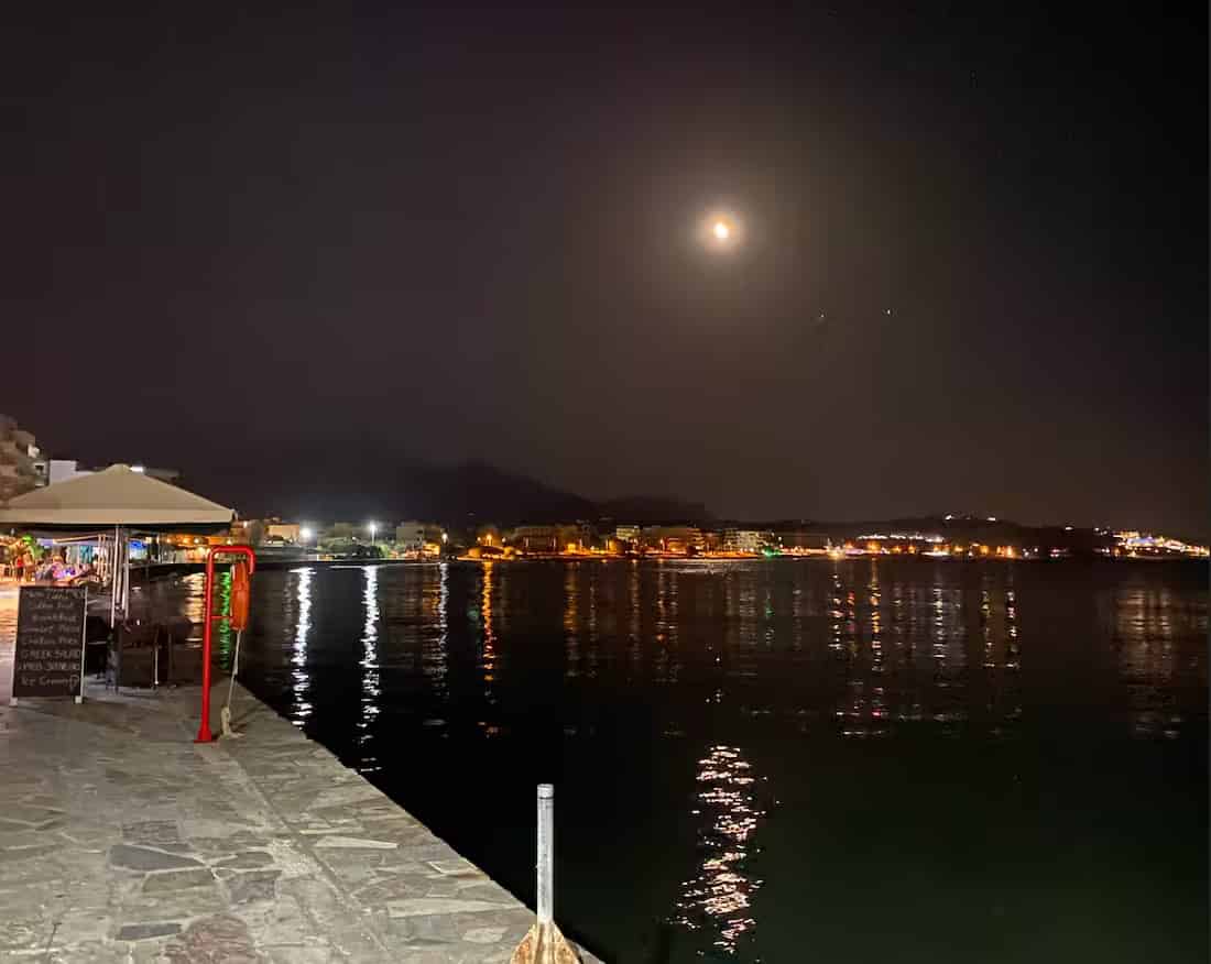 Φωτισμένη παραλιακή περατζάδα και λιμάνι της Ιεράπετρας, Νότια Κρήτη, με τα φώτα της πόλης να καθρεφτίζονται στη γαλήνια θάλασσα τη νύχτα