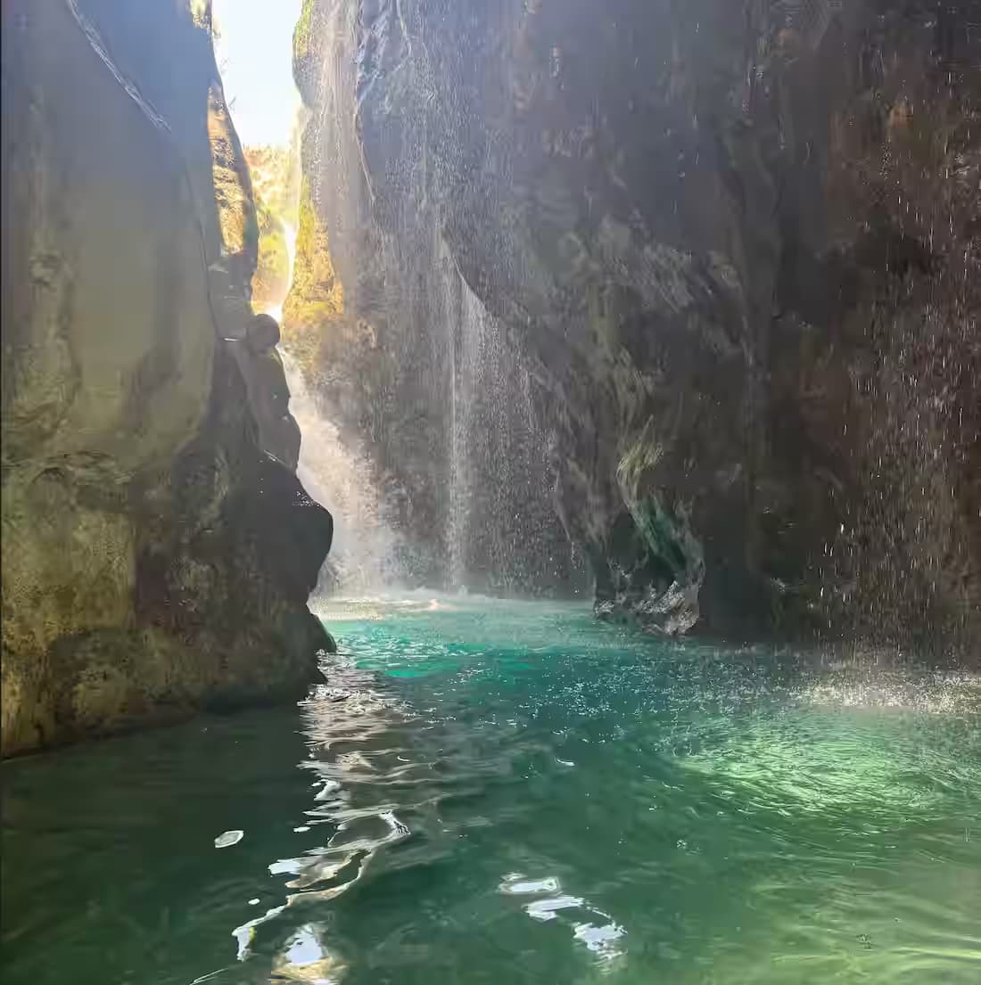 Secluded waterfall and turquoise swimming pool inside the dramatic Kourtaliotiko Gorge canyon, Rethymno, South Crete, Greece