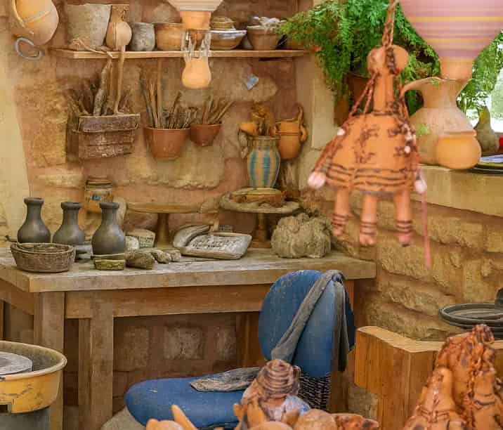 Ρουστίκ εσωτερικό παραδοσιακού κρητικού εργαστηρίου κεραμικής με πέτρινους τοίχους, πήλινα αγγεία και τοπικές λαϊκές τέχνες, Μαργαρίτες, Κρήτη