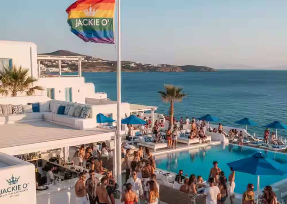 Gäste genießen einen sonnigen Tag am Pool des Jackie O' Beach Club auf Mykonos