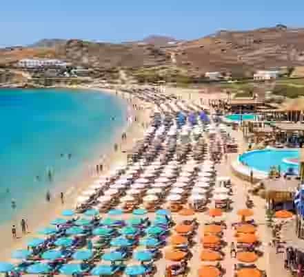 Luftaufnahme des Paraga Beach mit lebhaften Beach Clubs und Liegestühlen auf Mykonos