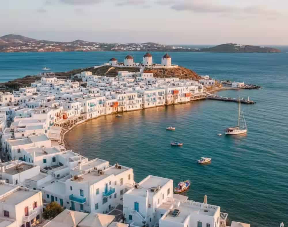 Die ikonischen Windmühlen von Mykonos und die Uferpromenade Klein-Venedigs bei Sonnenuntergang, Kykladen, Griechenland