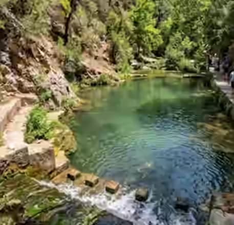 Kristallklarer See und üppiger grüner Wald der Sieben Quellen auf Rhodos – eine erfrischende Naturoase, leicht erreichbar mit dem Karpadu Mietwagen.