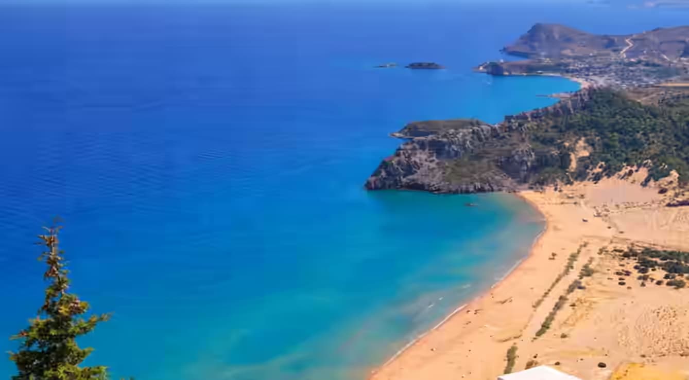Lotnicza panorama plaży Tsambika na Rodos ze złotym piaskiem i turkusową wodą – top destynacja z wynajętym samochodem Karpadu.