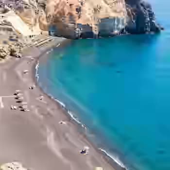 Plaże Perivolos i Mesa Pigadia na południowym wybrzeżu Santorini z czarnym wulkanicznym piaskiem i czystą niebieską wodą Morza Egejskiego