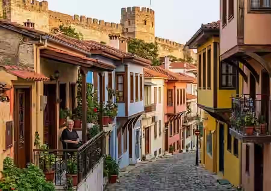 Malownicza brukowana uliczka w Ano Poli, starej dzielnicy Salonik, z tradycyjnymi kolorowymi domami i bizantynskimi murami - latwo dostepna wynajmowanym autem Karpadu.