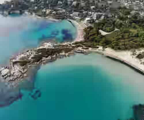Spettacolare vista aerea delle acque turchesi e delle baie bordate di pini a Sithonia, Calcidica - destinazione top da esplorare con l'auto a noleggio Karpadu.