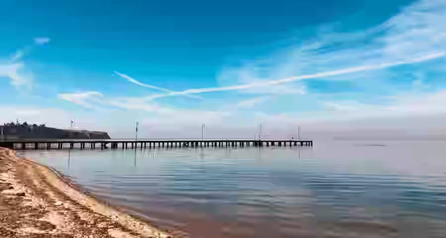 Η εμβληματική μακριά ξύλινη προβλήτα στην παραλία Αγίας Τριάδας κοντά στη Θεσσαλονίκη, ένας όμορφος παράκτιος προορισμός εύκολα προσβάσιμος με ενοικιαζόμενο αυτοκίνητο Karpadu.