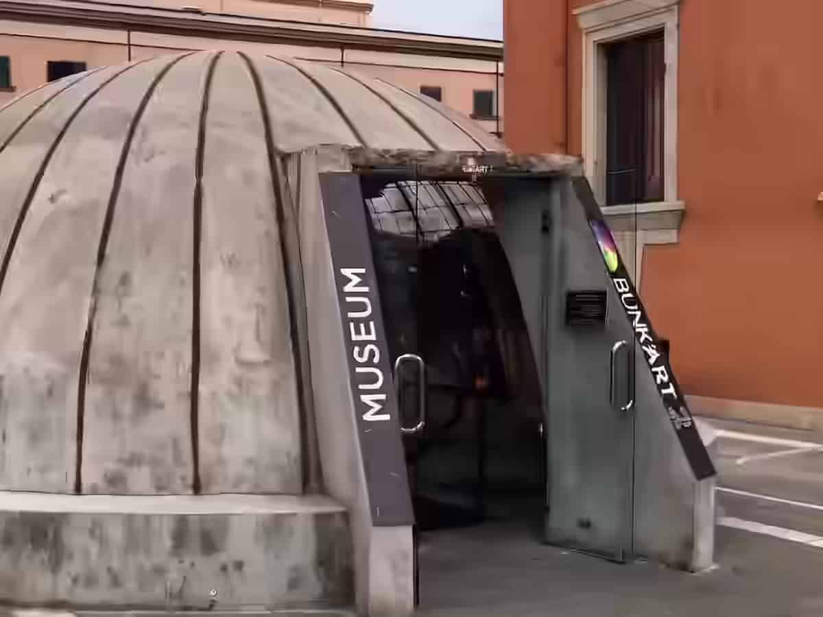 Intrarea din beton în formă de cupolă a muzeului Bunk'Art, cu ușile de sticlă deschise, în centrul orașului Tirana, Albania.