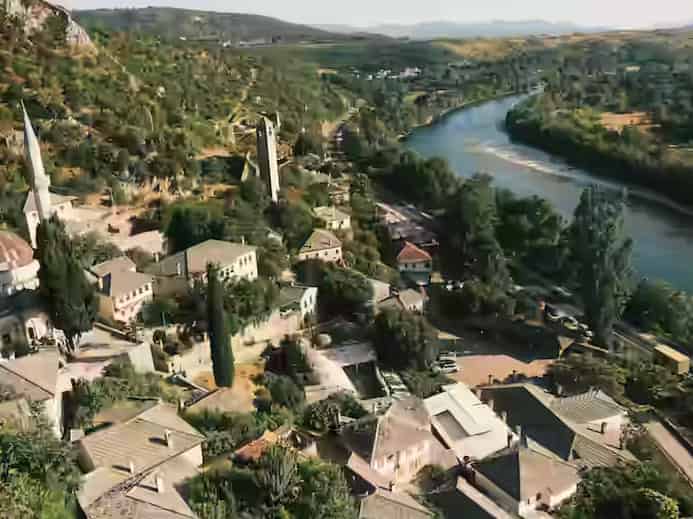 Istorijske kamene kuće, munara džamije i kula na strmoj padini Počitelja, Bosna i Hercegovina.