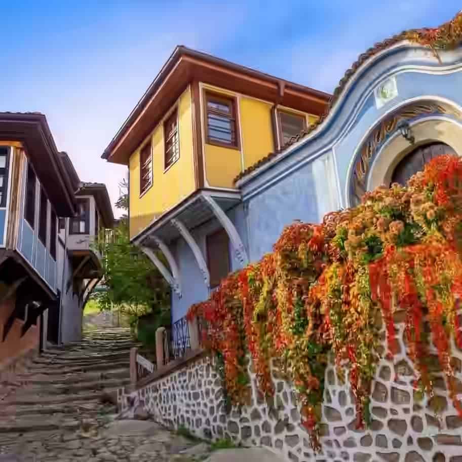 Bunte traditionelle Holzhäuser über einer steilen Kopfsteinpflastergasse in der Altstadt von Plowdiw, Bulgarien.