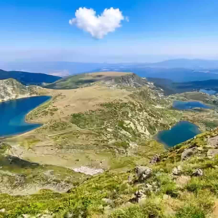 Mehrere tiefblaue Gletscherseen zwischen hohen, grasbewachsenen Kämmen des Rila-Gebirges, Bulgarien.