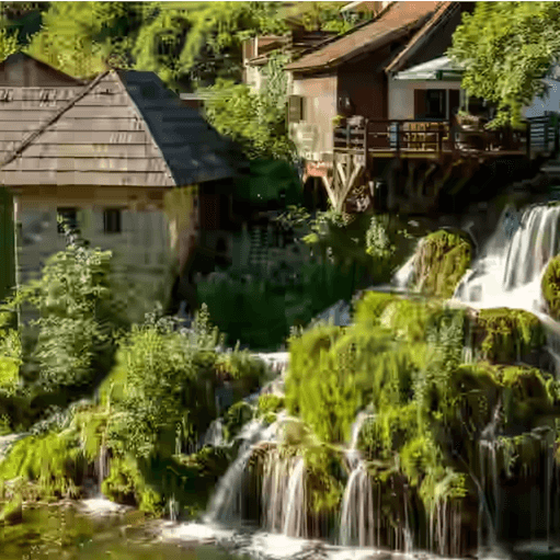 Wasser stürzt über bemooste Travertinkaskaden unter den alten hölzernen Wassermühlen von Rastoke bei Slunj, Kroatien.