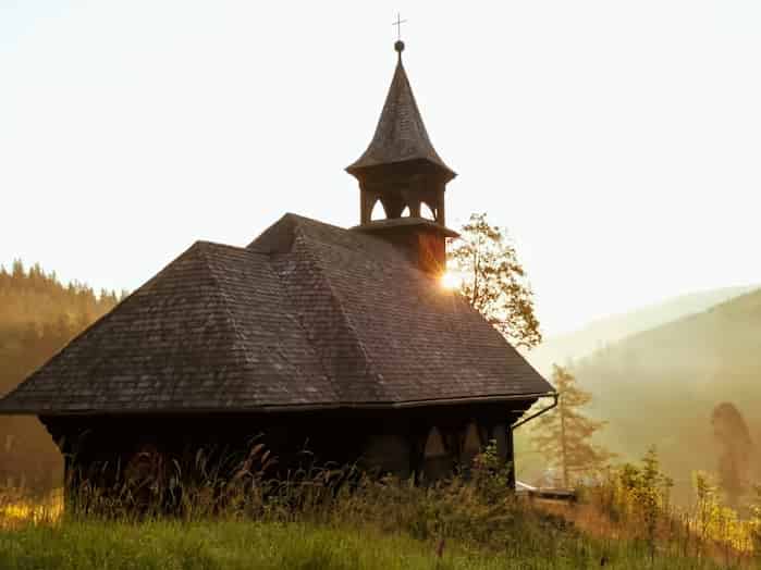 Eine kleine handgezimmerte Eichenkapelle mit schindelgedecktem Glockenturm in der Landschaft von Turopolje bei Zagreb, Kroatien.