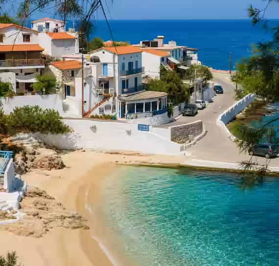 Charming houses overlooking the coastline and beaches of Armenistis village on the island of Ikaria, Greece.