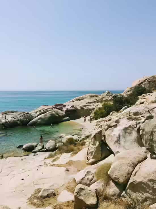 Dramatic rock formations and turquoise sea at Nas Beach, one of the most striking and wild spots in Ikaria, Greece.
