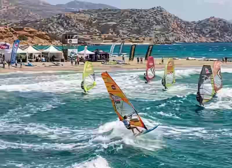 Windsurfeurs sur la baie d'Afiartis à Karpathos avec vagues déferlantes et vent Meltemi, site du Cabrinha PWA World Cup, Dodécanèse, Grèce