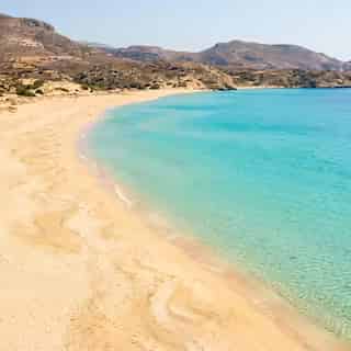 Longue plage de sable de Makris Gialos sur la côte sud de Karpathos avec eau turquoise et littoral désert, Dodécanèse, Grèce