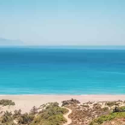 Θέα στο νησάκι Καστρί και τη μακριά αμμώδη παραλία της Κεφάλου στην Κω – μια κορυφαία διαδρομή της δυτικής ακτής με αυτοκίνητο της Karpadu.