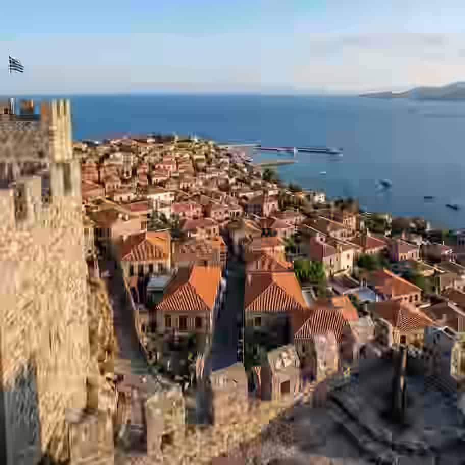 Vue panoramique en surplomb depuis les murailles historiques en pierre du Château de Molyvos, dominant un village pittoresque aux toits traditionnels en terre cuite, un petit port et le bleu profond de la mer Égée, à Lesbos, Grèce.