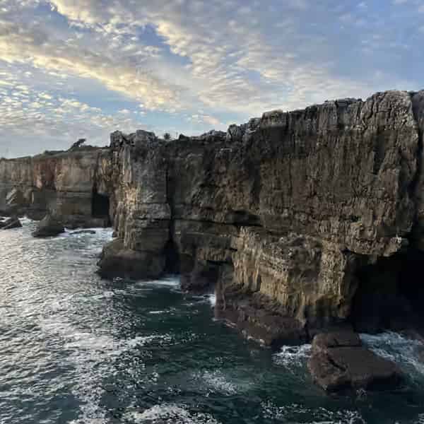 Hübsche Küstenbucht, Sandstrand und traditionelle Architektur im Badeort Cascais.