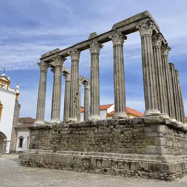 Säulen des antiken römischen Tempels und historische Bauten in der Stadt Évora.