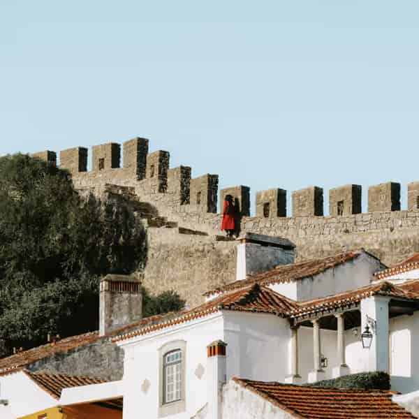 Uralte mittelalterliche Steinmauern, weiß getünchte Häuser und Burgtürme im Dorf Óbidos.