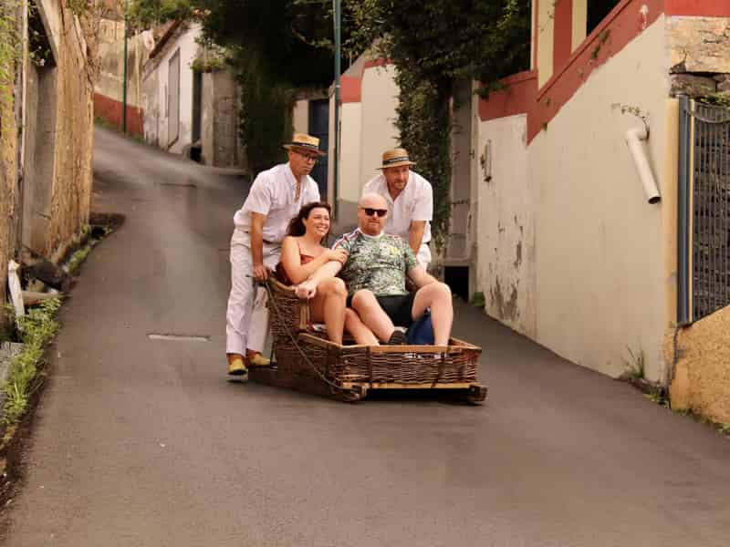 Traditionelle Korbschlittenfahrt die steilen Straßen von Monte auf Madeira hinunter.