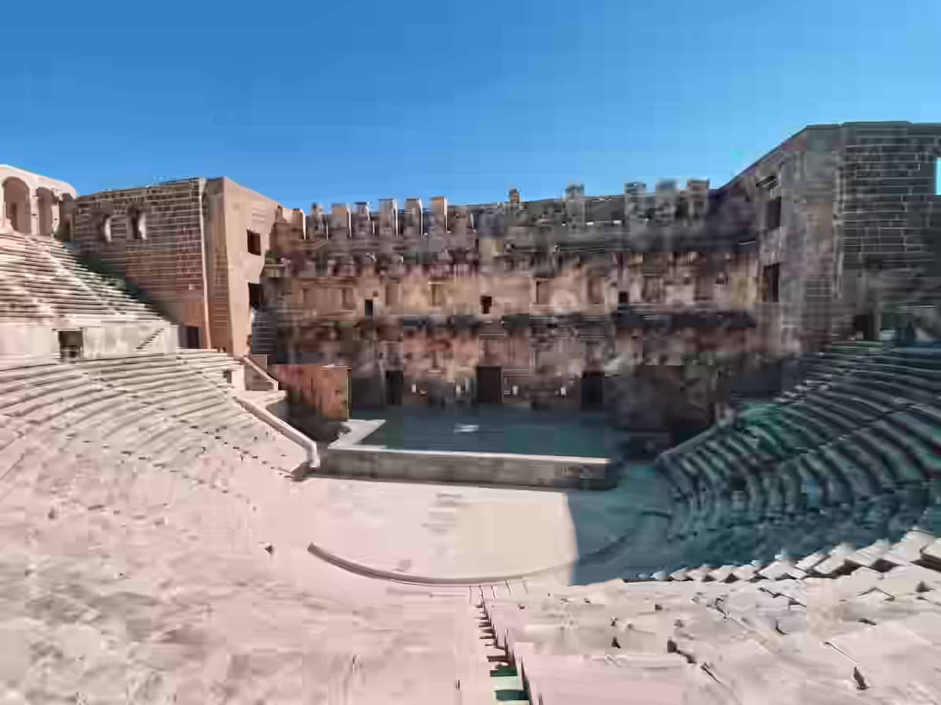 Rândurile curbate de piatră și zidul înalt de scenă ale teatrului roman antic de la Aspendos, lângă Antalya, Turcia.