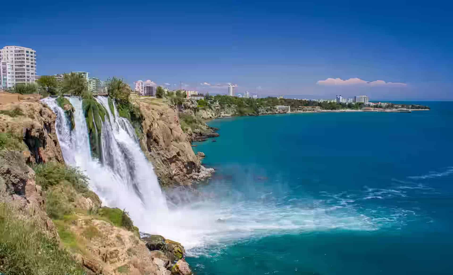 Apa albă a cascadei de jos Düden căzând de pe o faleză stâncoasă direct în mare, la Antalya, Turcia.