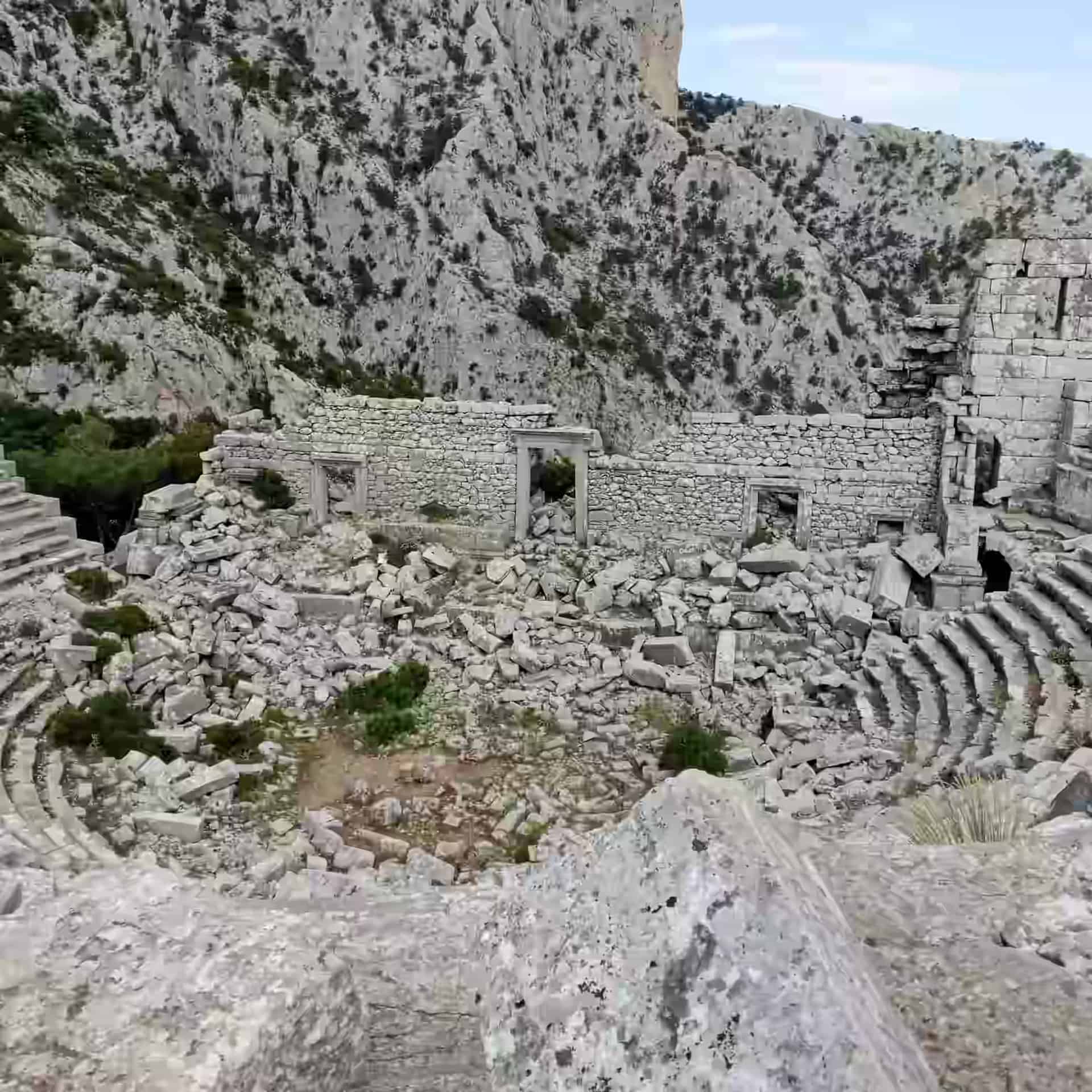 Blocurile de piatră împrăștiate ale teatrului antic în ruine, sus în munți la Termessos, lângă Antalya, Turcia.